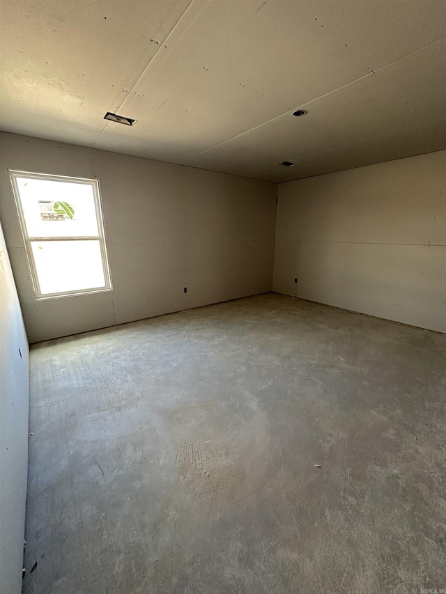 unfurnished room with concrete flooring