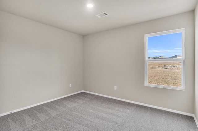 unfurnished room featuring baseboards, visible vents, and carpet floors