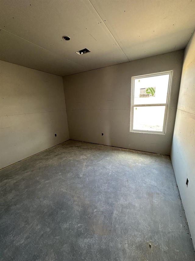 empty room with unfinished concrete flooring