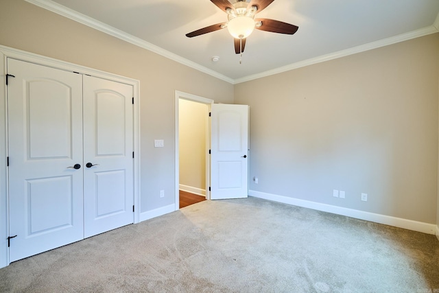 unfurnished bedroom with carpet flooring, a closet, ceiling fan, and ornamental molding