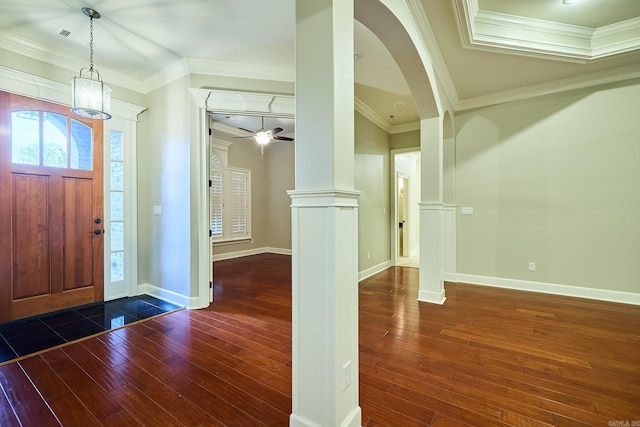 foyer with ceiling fan, ornate columns, crown molding, and dark wood-type flooring