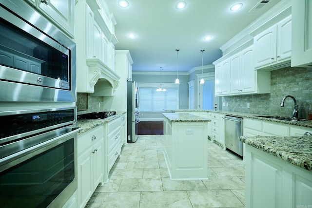 kitchen featuring light stone countertops, stainless steel appliances, white cabinets, and hanging light fixtures