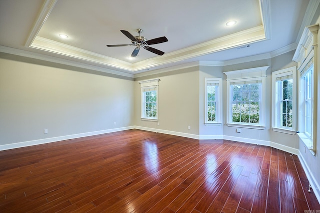 spare room featuring dark wood-type flooring, a tray ceiling, ceiling fan, and crown molding