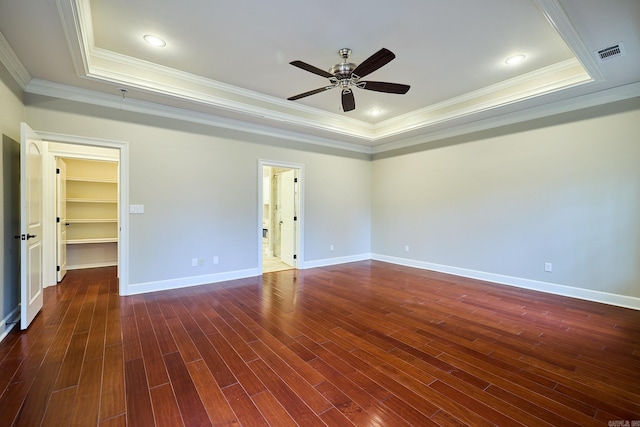 unfurnished room with dark hardwood / wood-style flooring, ceiling fan, a raised ceiling, and ornamental molding