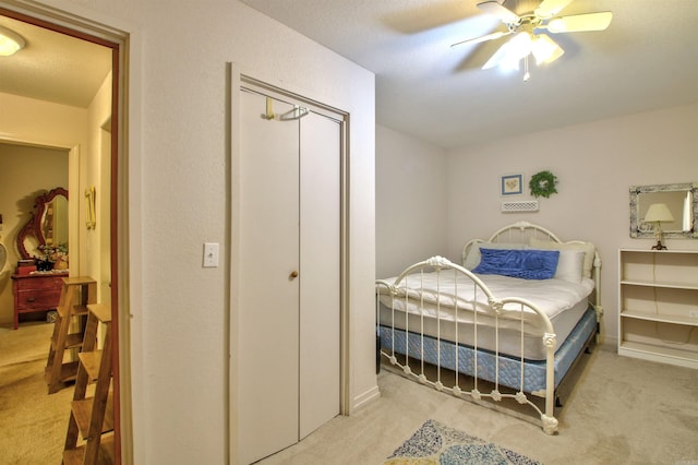 bedroom featuring light carpet, a closet, and ceiling fan