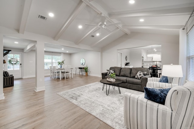 living room with vaulted ceiling with beams, ceiling fan, and light hardwood / wood-style floors