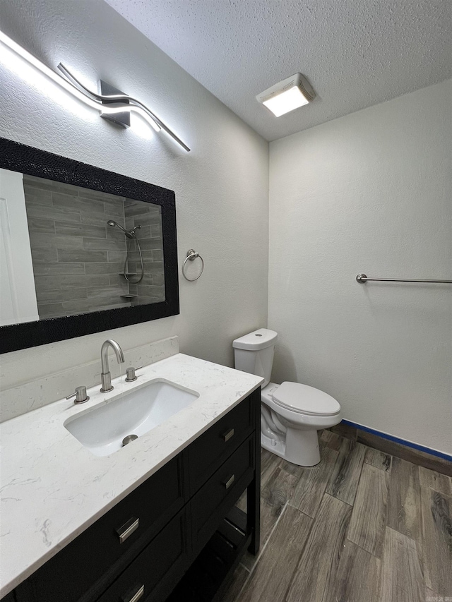 bathroom with vanity, toilet, and a textured ceiling