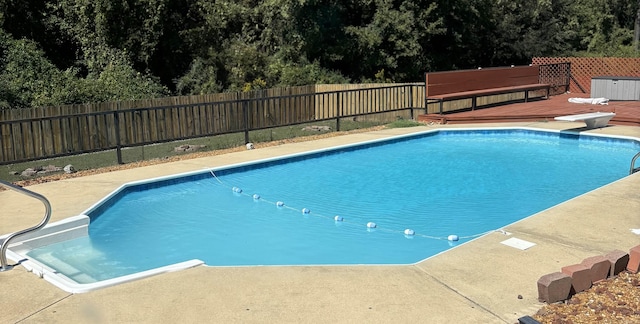 view of pool featuring a diving board and a wooden deck