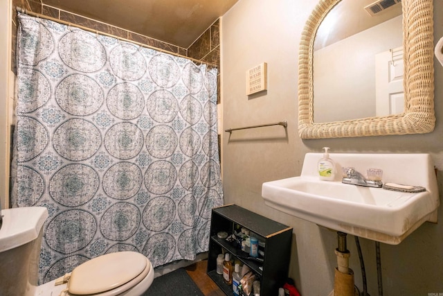 bathroom with a shower with curtain and toilet