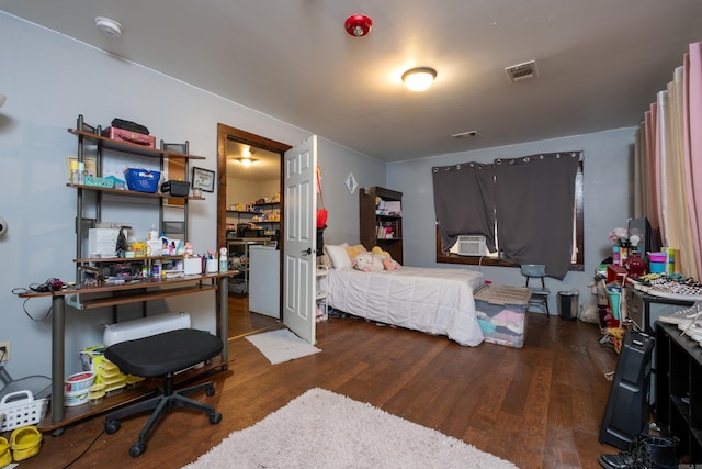 bedroom with dark hardwood / wood-style flooring and cooling unit