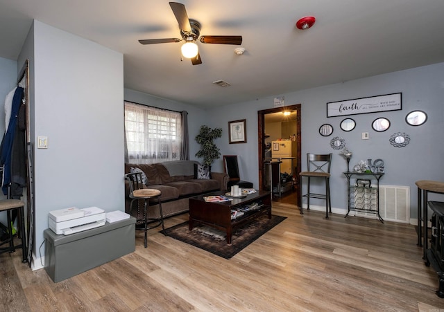 living room featuring ceiling fan and hardwood / wood-style flooring