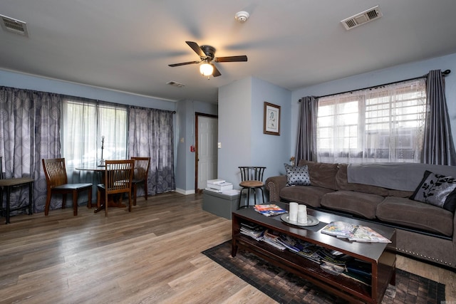 living room with ceiling fan, light hardwood / wood-style floors, and a wealth of natural light