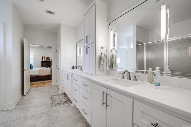 bathroom featuring vanity, tile patterned floors, and a shower with shower door