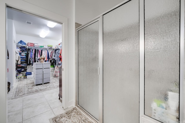 bathroom featuring tile patterned flooring and an enclosed shower