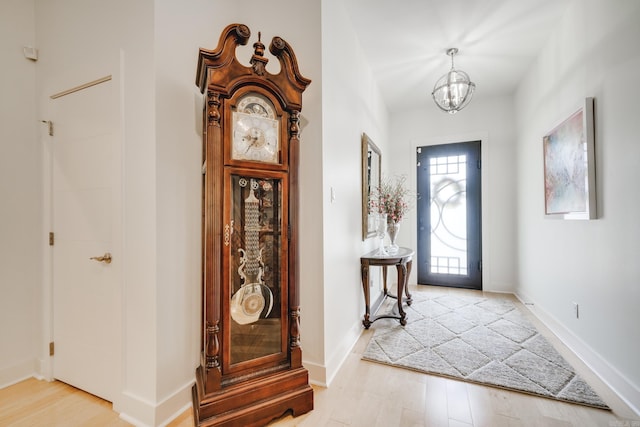 entrance foyer with light hardwood / wood-style flooring and an inviting chandelier