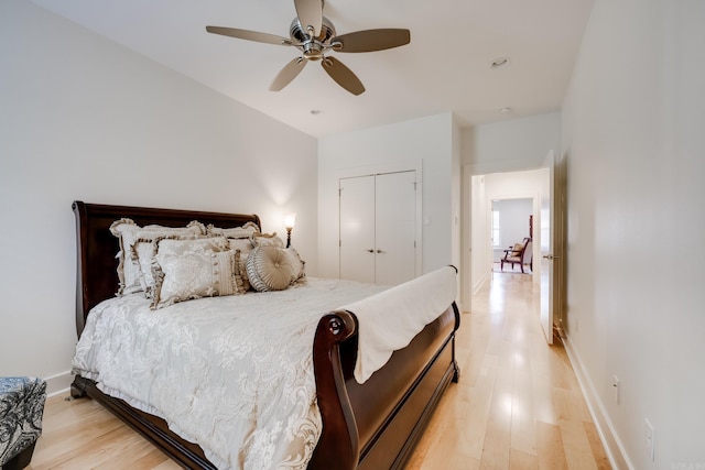 bedroom featuring ceiling fan, light hardwood / wood-style flooring, and a closet