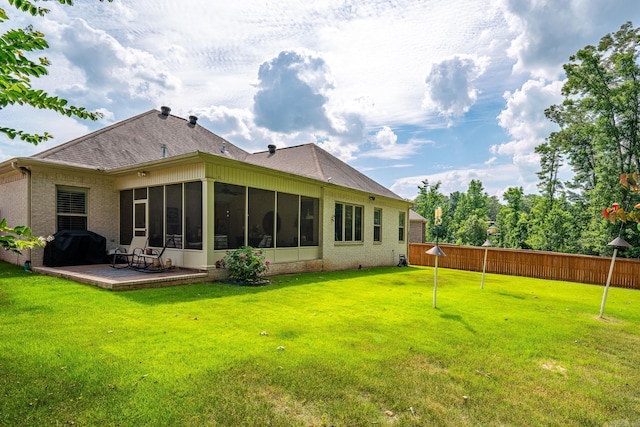 rear view of house featuring a lawn and a sunroom