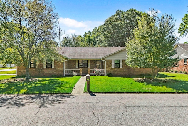 ranch-style house featuring a porch and a front lawn