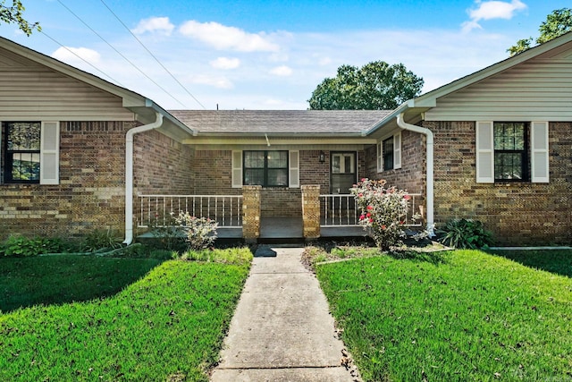 entrance to property featuring a lawn and a porch