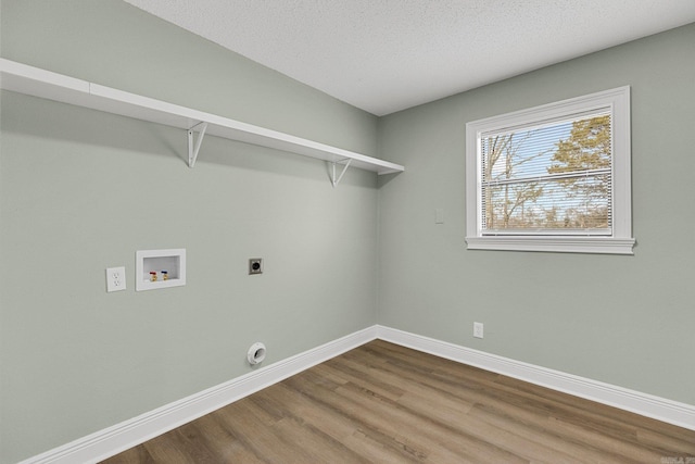 washroom with hookup for an electric dryer, hookup for a washing machine, a textured ceiling, and wood-type flooring