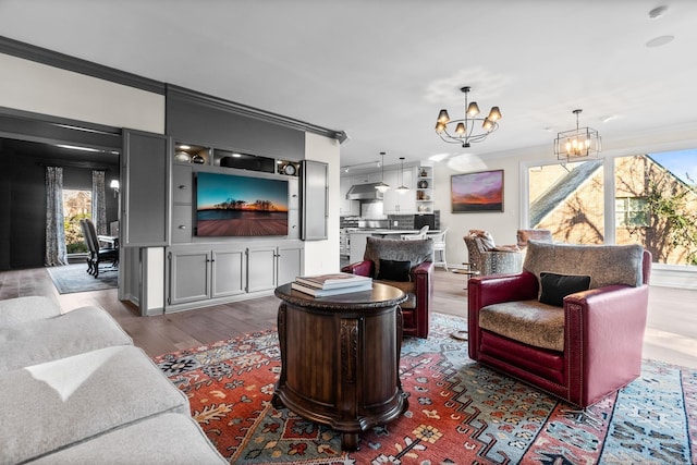 living room featuring dark hardwood / wood-style floors, ornamental molding, and an inviting chandelier