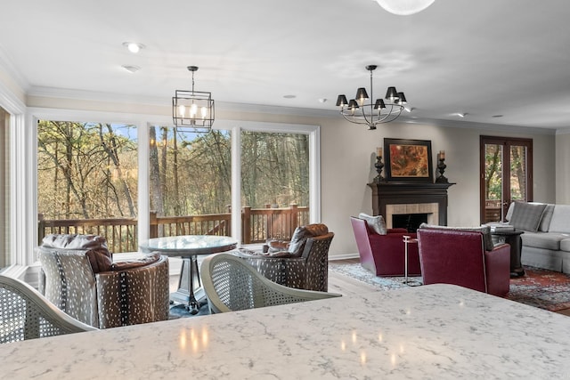 dining space with crown molding, a fireplace, hardwood / wood-style flooring, and an inviting chandelier