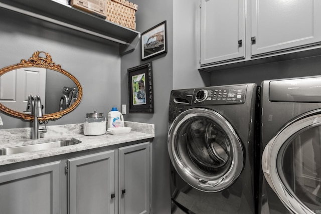 laundry room with washer and dryer, cabinets, and sink