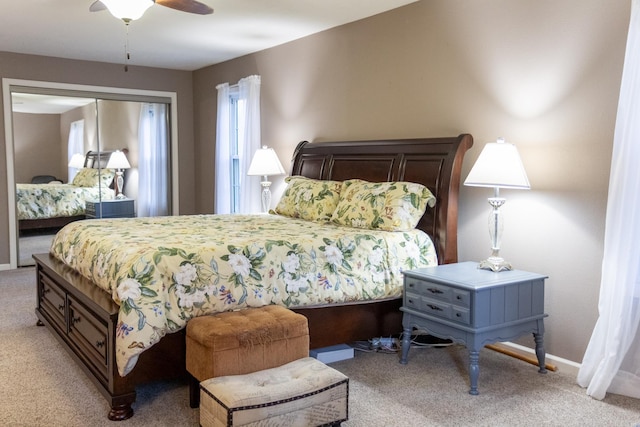 carpeted bedroom with ceiling fan and a closet