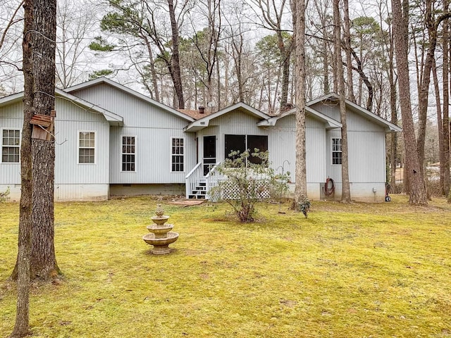 rear view of house featuring a lawn