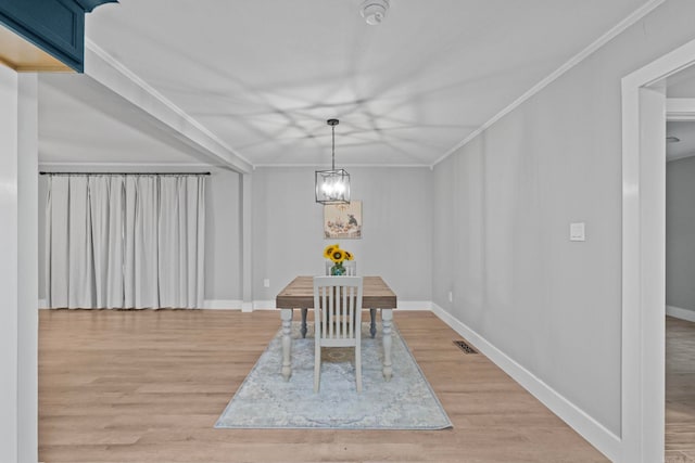 unfurnished dining area featuring wood-type flooring, an inviting chandelier, and ornamental molding