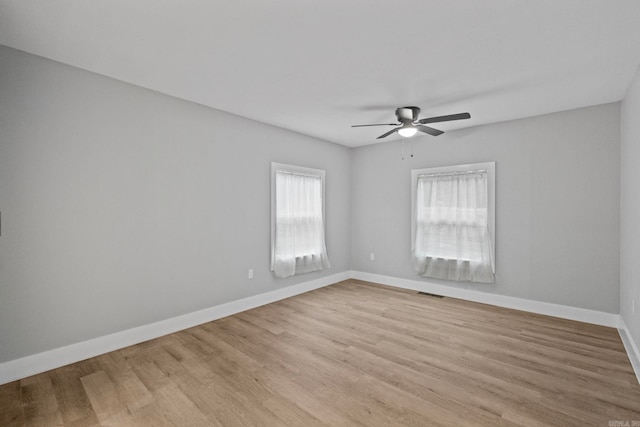 spare room with ceiling fan and light wood-type flooring