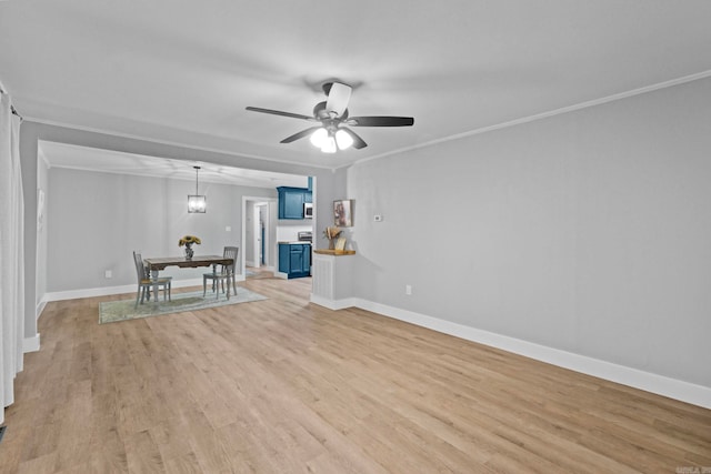 unfurnished living room featuring ceiling fan with notable chandelier, light hardwood / wood-style floors, and crown molding