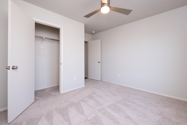 unfurnished bedroom featuring ceiling fan, a closet, and light colored carpet