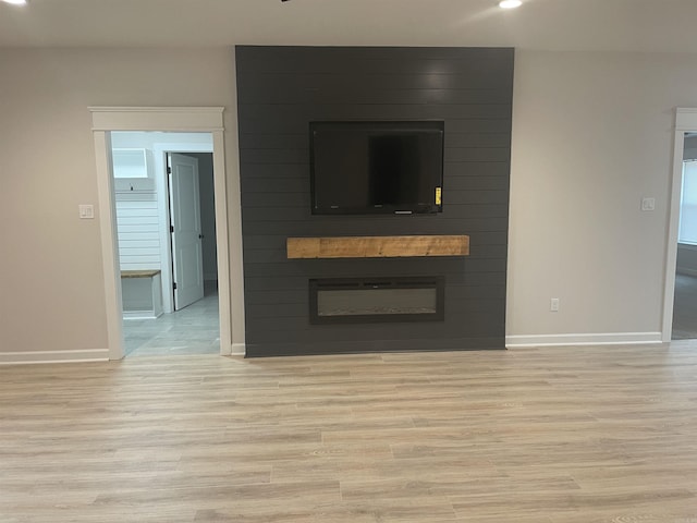 unfurnished living room with a fireplace and light hardwood / wood-style floors