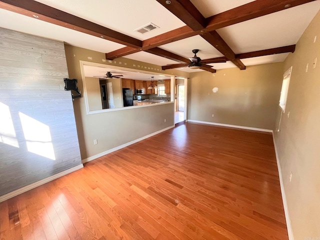 unfurnished living room with beamed ceiling, light wood-type flooring, and coffered ceiling