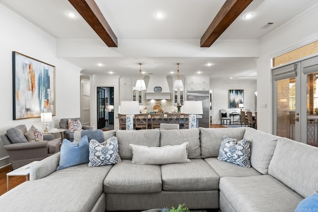 living room with beamed ceiling, hardwood / wood-style floors, and ornamental molding