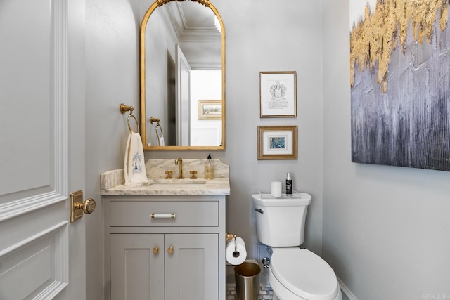 bathroom with vanity, toilet, and ornamental molding