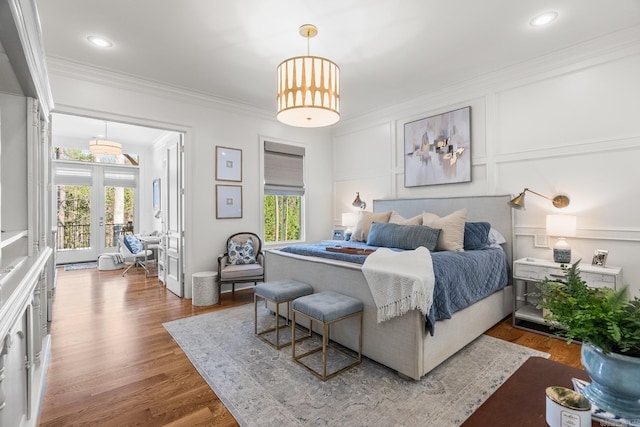 bedroom with wood-type flooring, multiple windows, and ornamental molding