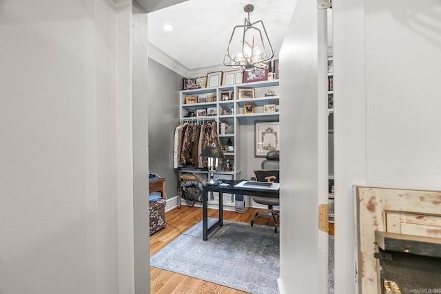 home office featuring ornamental molding, wood-type flooring, and an inviting chandelier