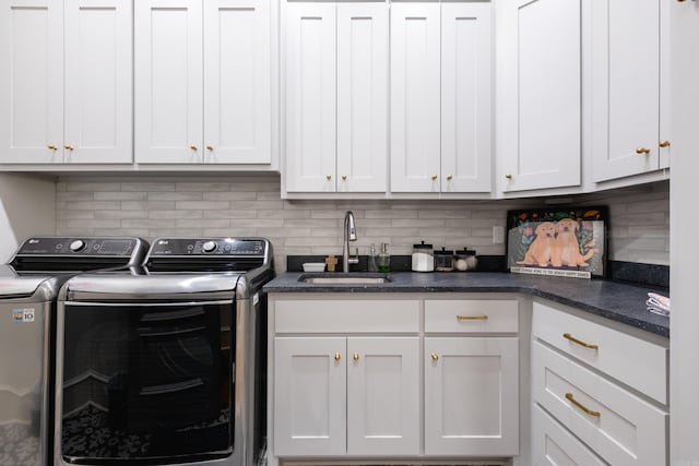 laundry area featuring washer and clothes dryer, cabinets, and sink