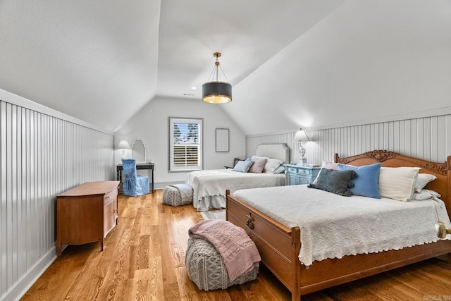 bedroom with light hardwood / wood-style floors and lofted ceiling