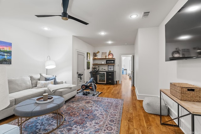 living room with light wood-type flooring and ceiling fan