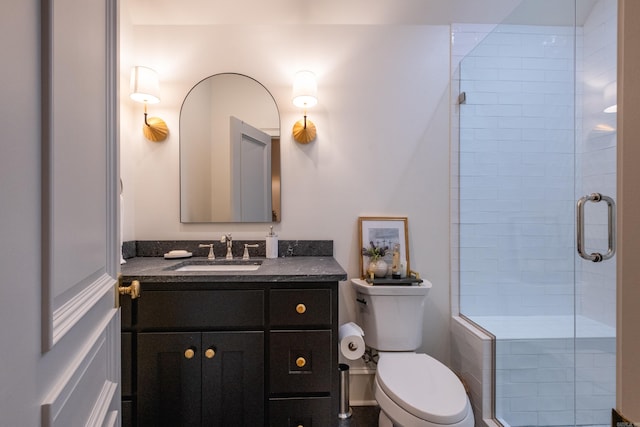 bathroom featuring vanity, toilet, and a shower with shower door