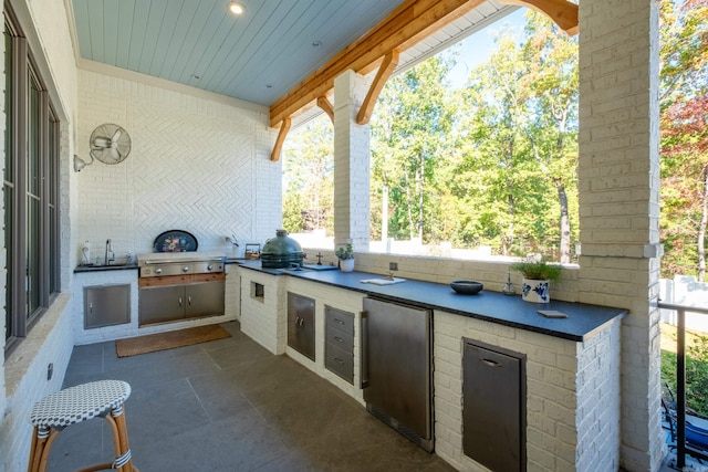 view of patio / terrace with a grill, sink, and an outdoor kitchen