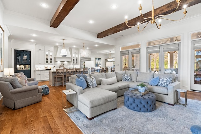 living room with french doors, ornamental molding, hardwood / wood-style flooring, a notable chandelier, and beamed ceiling