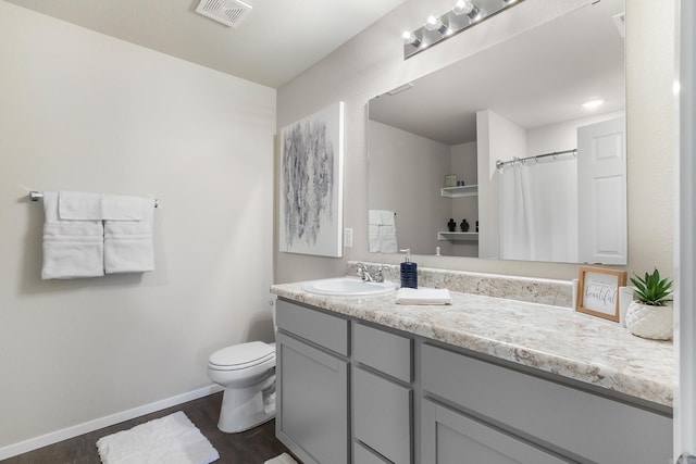 bathroom featuring toilet, vanity, and hardwood / wood-style flooring