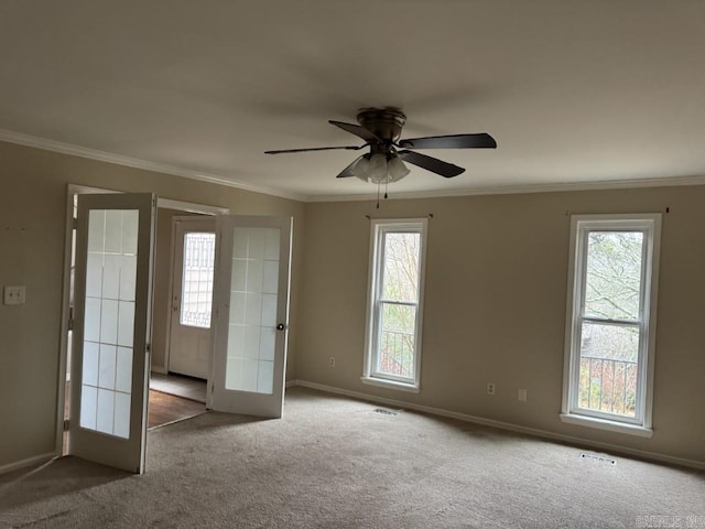 carpeted empty room with crown molding, french doors, ceiling fan, and a healthy amount of sunlight