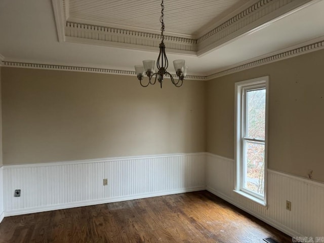 unfurnished room featuring hardwood / wood-style floors, ornamental molding, and an inviting chandelier