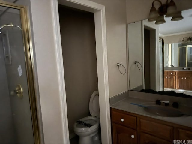 bathroom with walk in shower, vanity, ornamental molding, and toilet