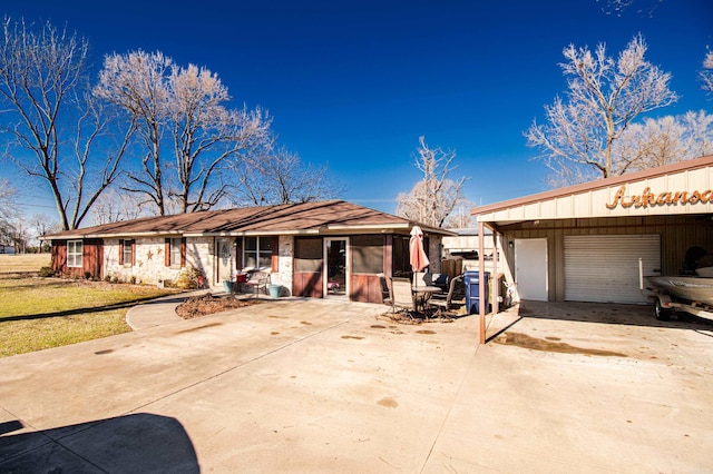 single story home featuring a sunroom, a garage, and a front lawn